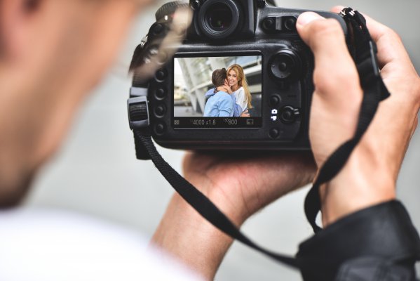 man looking at photo on dslr camera